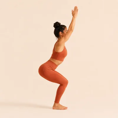 Chair Pose: hips sinking back and down with the arms sweeping up alongside the ears.