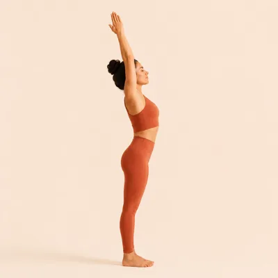 Sweeping the arms overhead on an inhale, lengthening the spine before the fold.