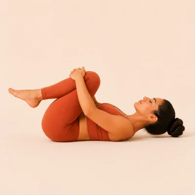 Wind Release Pose: both knees drawn into the chest with the arms wrapped around the shins.